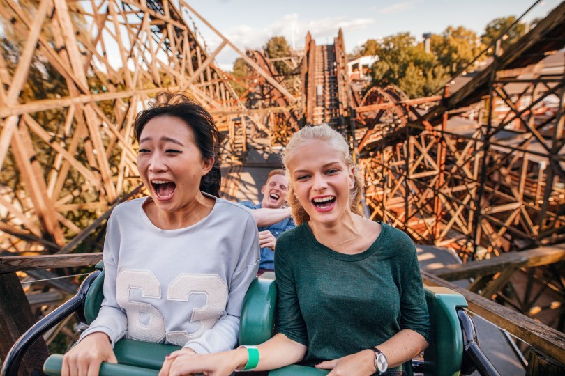 young-friends-riding-roller-coaster