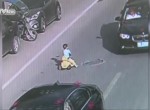 Kid drives toy car through traffic on busy road